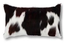 a black and white cowhide pillow on a white background