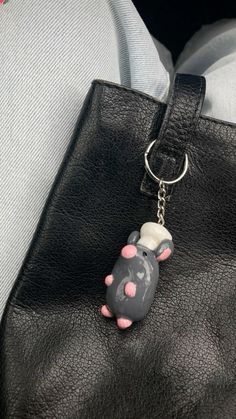 an elephant keychain hanging from a black purse