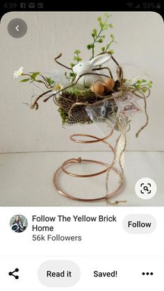 an image of a bird nest with eggs and flowers in it's nest on the table