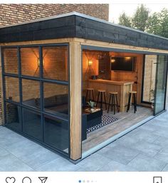 an outdoor bar with stools and barstools in front of a brick building