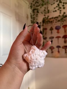 a hand holding a tiny crocheted object in it's palm