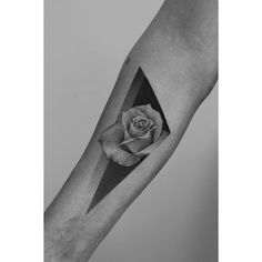 a black and white photo of a rose on the left arm with an arrow in it