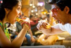 a man eating food next to a woman