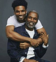 two men hugging each other and smiling