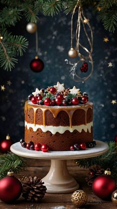 a christmas cake with icing and cranberries sits on a pedestal surrounded by decorations