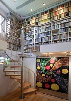 a spiral staircase in front of a book shelf filled with books