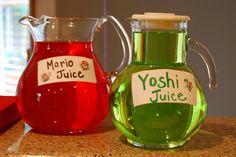 two pitchers filled with liquid sitting on top of a counter