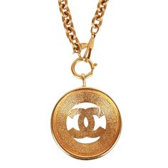 This vintage 1980's necklace features a large classic CC medallion with a sunburst design, long rolo chain and a springring/hook closure in 24K gold plated metal. Origin: France Condition: Vintage; Excellent - this necklace shows mild signs of wear, including light scratching, pitting, and some darkening near the chain links. Accompanied by: Chanel box Measurements: 16" chain, 2.25" x 2.25" pendant Vintage Gold Necklace With Gold-tone Logo Plaque, Vintage Metal Necklace With Logo Charm, Vintage Jewelry With Gold-tone Logo Plaque, Vintage Yellow Gold Jewelry With Logo Charm, Gold Metal Necklaces With Gold-tone Logo Plaque, Luxury Gold Chain Medallion Necklace, Luxury Gold Chain Necklace With Medallion, Vintage Gold-tone Jewelry With Logo Charm, Vintage Gold-tone Necklace With Logo Charm