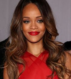 a close up of a person wearing a red dress with long wavy hair and lipstick