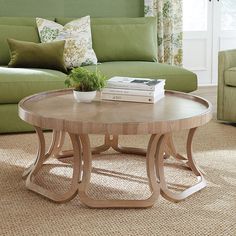 a living room with green couches and a coffee table in front of a window