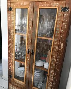 an old wooden china cabinet with glass doors