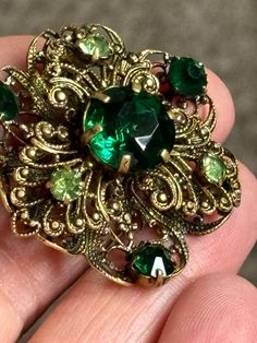 Vintage gold tone filagree work brooch,roll over clasp, set with claw set deep green crystal stones