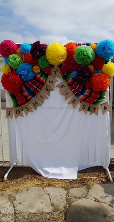 a white table topped with lots of colorful pom poms on top of it