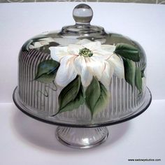 a glass cake plate with a flower painted on it