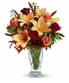 a vase filled with lots of orange and red flowers