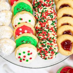 an assortment of christmas cookies and pastries on a platter with candy canes