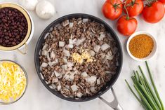 ingredients to make an enchilada are shown in bowls on a marble countertop