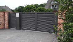 a brick fence and gate in front of a house