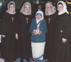 a group of women standing next to each other in front of a glass building and wearing nun costumes