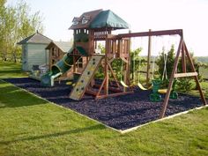 a wooden swing set in the middle of a yard