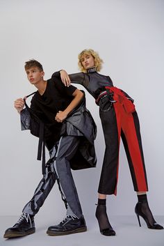 two people in black and red clothing posing for a photo together with one person wearing high heeled shoes