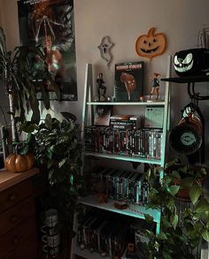 a living room filled with lots of halloween decorations and bookshelves full of movies