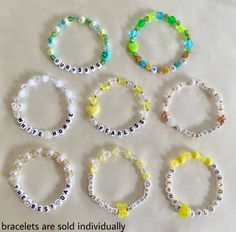 six bracelets are arranged in different colors and sizes on a white surface with the words beaded together