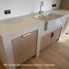 a white kitchen sink sitting under a faucet next to a counter with two sinks