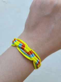 a person wearing a yellow and blue bracelet