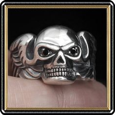 Our Biker Winged Skull ring will put a great look of biker metal on your finger. Plenty of the right stuff is around this fine designed ring. Stone set eyes, double winged sides and more. Very well made and completely handcrafted. Just perfect for those into heavy custom biker skull pieces. Pure quality in style and design! Metal is .925 Sterling Silver Sizes 10 and 11 US Ring Top Measure Is 16mm x 22mm Stones are Genuine Black Onyx Casting by Rainbow. "We Do Not" ship to Thailand. Export Only! Silver Skull Ring For Biker Events And Halloween, Black Biker Skull Ring Gift, Black Biker Style Skull Ring As Gift, Black Punk Skull Ring Collectible, Black Punk Style Skull Ring Collectible, Black Biker Style Ring As Gift, Black Gothic Skull Ring For Biker Events, Black Skull Ring For Biker Events, Gothic Silver Skull Ring For Biker Events