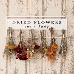 dried flowers hang on a sign that says dried flowers cut and hung