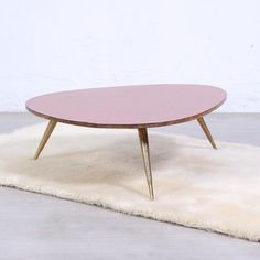 a pink table sitting on top of a white rug