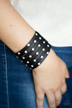 a woman wearing a black and white polka dot bracelet