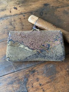 an old purse sitting on top of a wooden floor next to a rolling pin with a map on it