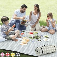 a group of people sitting on top of a blanket in the grass eating and drinking