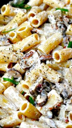 pasta with mushrooms and spinach in a black bowl