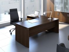 an office desk in the middle of a room with windows and blinds on both sides