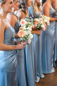 a group of women standing next to each other holding bouquets