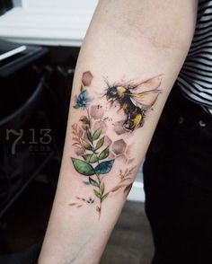 a woman's arm with flowers and a bee on it