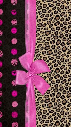 a pink bow on top of a leopard print wallpaper with black and pink stripes