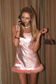 a woman in a pink dress talking on a cell phone