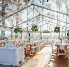 the inside of a large tent with tables and chairs set up for a formal function