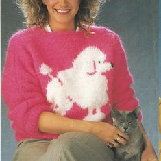 a woman in a pink sweater holding a cat and smiling at the camera while sitting down