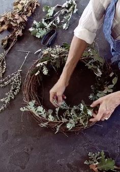 a person is making a wreath out of branches