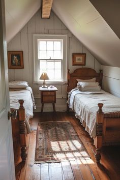 two beds in a room with white walls and wooden floors, one has a rug on the floor