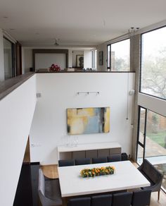 a dining room table with chairs and a painting on the wall