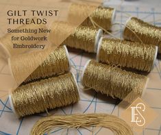 several spools of gold thread sitting on top of a table