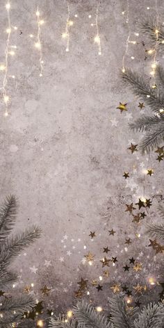 christmas tree branches with gold stars and sparkles on a grungy gray background