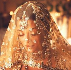 a woman wearing a gold veil and jewelry