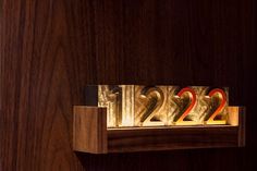 a wooden clock with two red numbers on it's face and the number 22